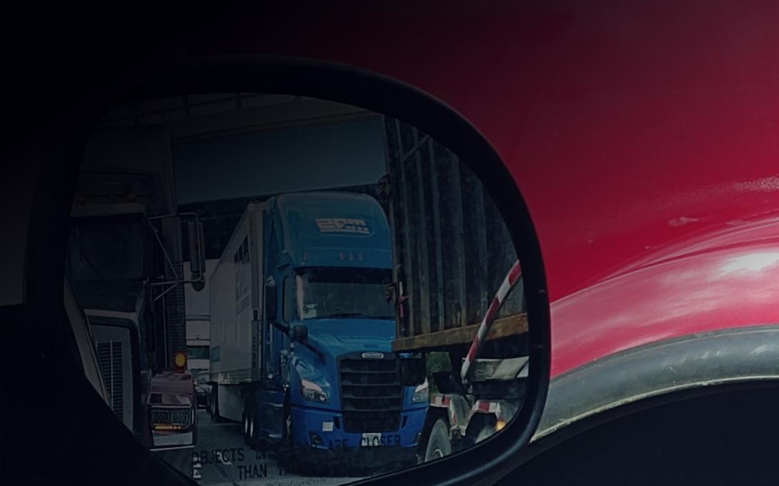 Photo of semi trucks in rearview mirror