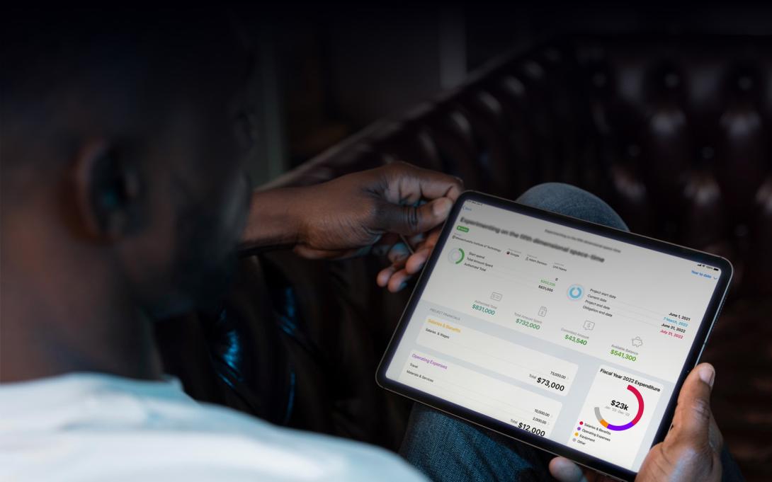 Photo of man holding tablet device with dashboard on screen